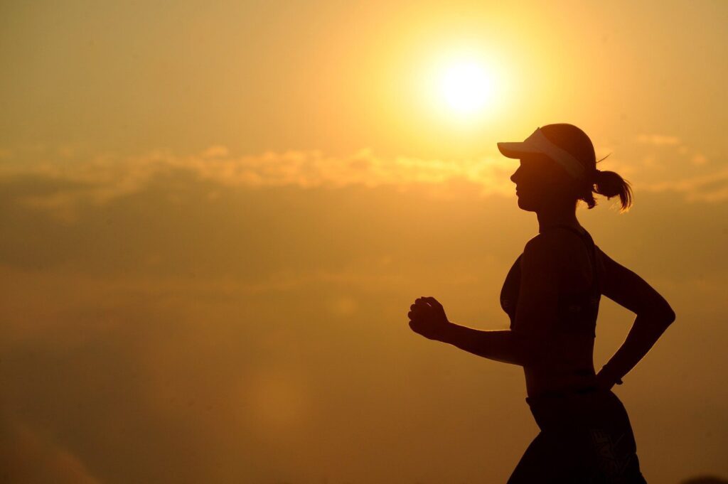 Silhouette of a woman running at sunrise — sustained aerobic exercise, the trigger for the BDNF window and neuroplasticity